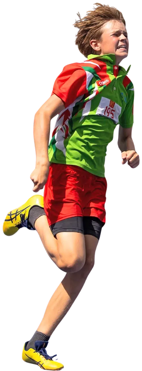 Boy Sprinting in Athletic Race on Blue Track A young boy running on a blue track during a race, wearing a red and green athletic uniform with the number "195." He looks focused and determined. Other athletes, including boys and girls in various uniforms, are visible in the background. A person can be seen in the background raising a flag.
